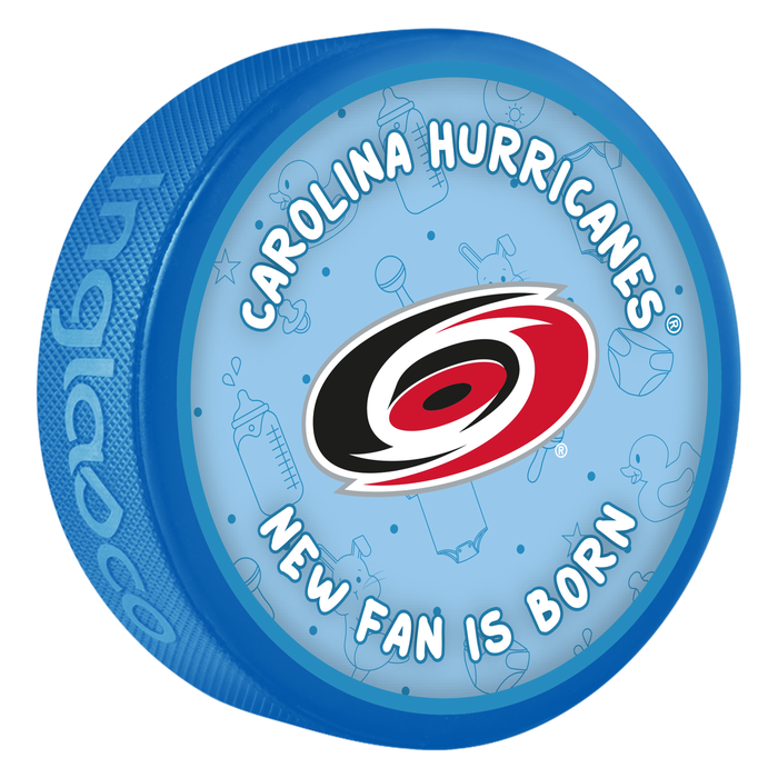 NHL Carolina Hurricanes New Fan Is Born blue souvenir hockey puck with red and black hurricane swirl logo on baby-themed background